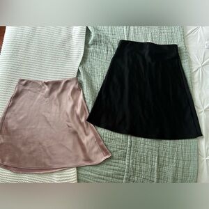 Black and Pink Dynamite satin skirts, both in XXS.